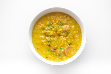 Sächsische Kartoffelsuppe mit Bockwurst in einer weißen Schale freigestellt vor weißem Hintergrund