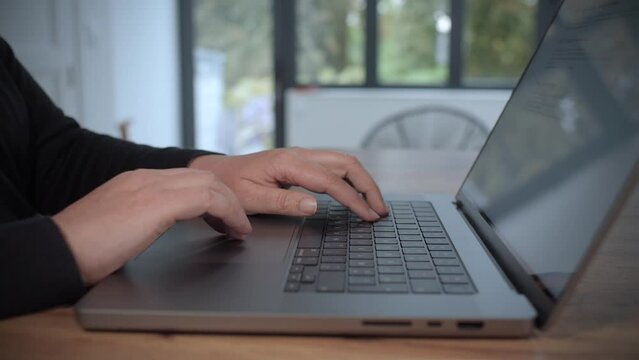 Femme qui travaille sur un ordinateur portable. Gros plan sur les mains et le clavier. Plan en travelling lent. Vid&eacute;o 4K