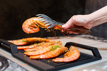 Close-up. Tiger prawns are fried on an electric grill in the kitchen.