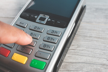 Obraz premium Closed hand socket by entering code in payment terminal. concept purchases with cards
