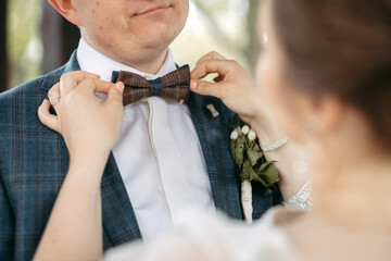 Groom fixing bow tie on his wedding day