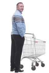 rear view. casual man with a cart standing in front of a white screen