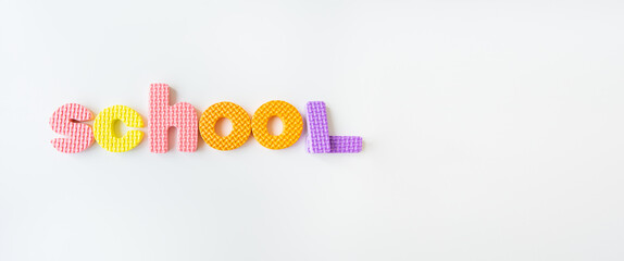 Banner with multi-colored letters. Letters for the study of children in kindergarten or school, fluted letters. School inscription.