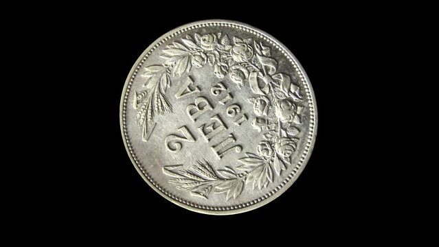Rotating reverse of Bulgarian coin 2 leva, 1912 with inscription meaning TWO LEVS. Isolated in black background.