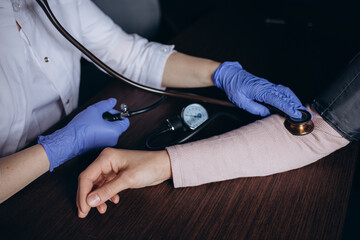 Doctor cardiologist measuring blood pressure to patient with tonometer. Diagnosis of arterial...