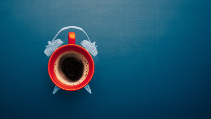 Coffee cup top view with manual alarm clock on a chalkboard background. Break time, good morning, drinks menu design concept. Copy space