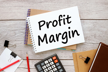 profit margin. two notebooks on the table with text