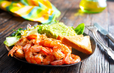 helthy breakfast. fried shrimps with avocado and toasts
