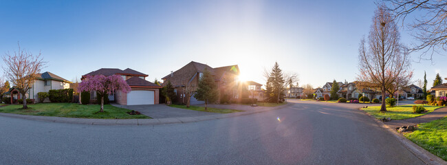 Residential neighborhood Street in Modern City Suburbs. Sunny Spring Morning Sunrise. Fraser Heights, Surrey, Greater Vancouver, British Columbia, Canada. Panorama