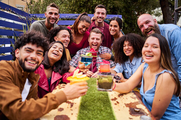 Selfie group of People cheers and having fun. Multiracial happy friends drinking and toasting cocktails at brewery bar taking photo together