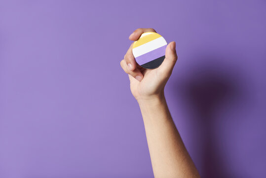 Hand Raising A Non Binary Flag Badge; Gender Diversity, Identity Pride