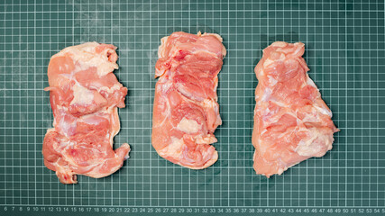 Raw skinless boneless chicken thigh, for cooking.Chicken thigh,leg meat on a line board.