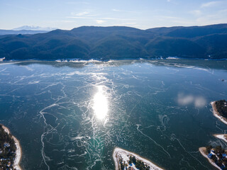 Aerial winter view of Dospat Reservoir covered with ice, Bulgaria