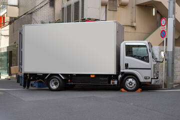 Japan Cargo truck with a blank container for Mockup parking in front of the building background