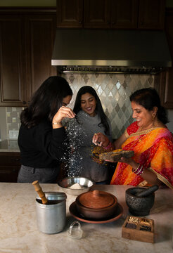 Mother and daughters in the kitchen - having fun 