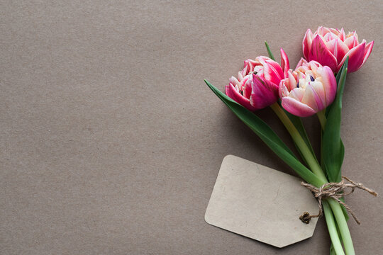 Small bouquet of pink tulips with a blank tag