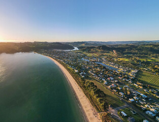 Sunrise over Cooks Beach coastline along the Coromandel Peninsula in New Zealand's North Island.
