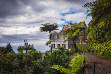 Fototapeta na wymiar Panoramic view of Monte tropical garden with exotic vegetation surrounding the pond in Madeira island in Portugal. Long exposure picture. October 2021