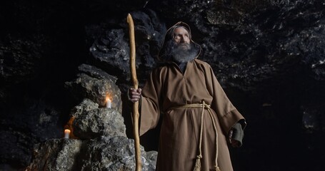 Fototapeta premium Elderly sorcerer standing inside cave