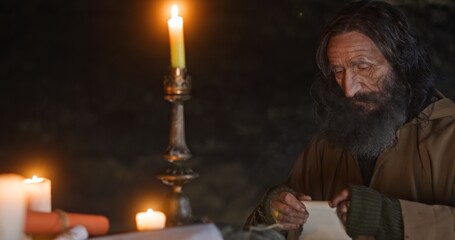 Aged hermit preparing to send letter