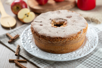 Sponge cake or chiffon cake with apples so soft and delicious sliced ​​with ingredients: cinnamon, eggs, flour, apples on wooden table. Home bakery concept for background and wallpaper