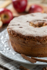 Sponge cake or chiffon cake with apples so soft and delicious sliced ​​with ingredients: cinnamon, eggs, flour, apples on wooden table. Home bakery concept for background and wallpaper