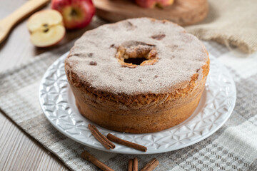 Sponge cake or chiffon cake with apples so soft and delicious sliced ​​with ingredients: cinnamon, eggs, flour, apples on wooden table. Home bakery concept for background and wallpaper