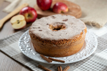 Sponge cake or chiffon cake with apples so soft and delicious sliced ​​with ingredients: cinnamon, eggs, flour, apples on wooden table. Home bakery concept for background and wallpaper