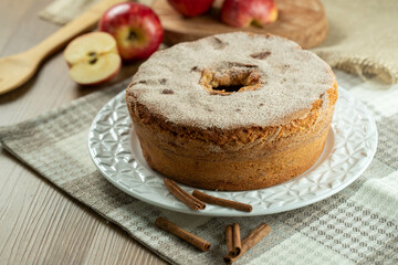 Sponge cake or chiffon cake with apples so soft and delicious sliced ​​with ingredients: cinnamon, eggs, flour, apples on wooden table. Home bakery concept for background and wallpaper