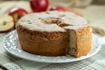 Sponge cake or chiffon cake with apples so soft and delicious sliced ​​with ingredients: cinnamon, eggs, flour, apples on wooden table. Home bakery concept for background and wallpaper