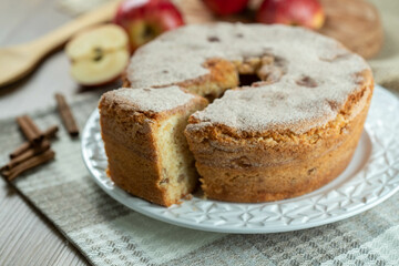 piece of Sponge cake or chiffon cake with apples so soft and delicious sliced ​​with ingredients: cinnamon, eggs, flour, apples on wooden table. Home bakery concept for background and wallpaper