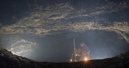 Hermit with lamp entering cave