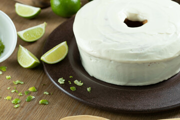 Moist lemon fruit cake on plate with lemon slices on wooden table. Delicious breakfast, traditional tea time. Lemon cake recipe.