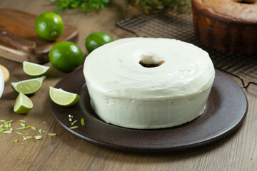 Moist lemon fruit cake on plate with lemon slices on wooden table. Delicious breakfast, traditional tea time. Lemon cake recipe.