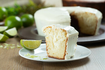 Close up piece of Moist lemon fruit cake on plate with lemon slices on wooden table. Delicious breakfast, traditional tea time. Lemon cake recipe.