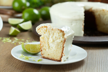 Close up piece of Moist lemon fruit cake on plate with lemon slices on wooden table. Delicious breakfast, traditional tea time. Lemon cake recipe.