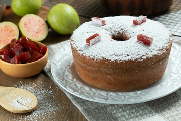 Brazilian corn cake made with a type of corn flour (Fuba) filled with guava paste. On a wooden party table. Typical sweets of the June festival. Cornmeal cake