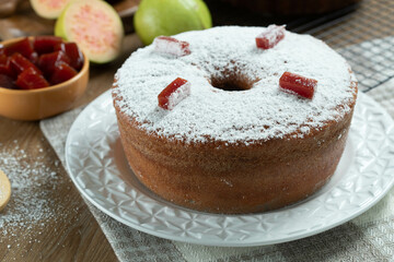 Brazilian corn cake made with a type of corn flour (Fuba) filled with guava paste. On a wooden party table. Typical sweets of the June festival. Cornmeal cake