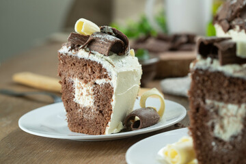 Close up piece of White chocolate and dark chocolate cake two loves on wooden table. Birthday and wedding cake