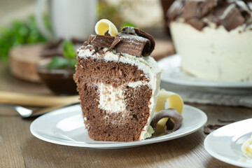 Close up piece of White chocolate and dark chocolate cake two loves on wooden table. Birthday and wedding cake