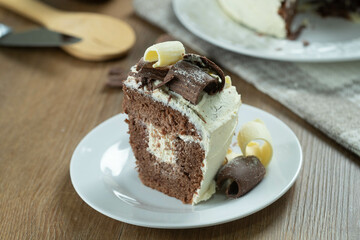Close up piece of White chocolate and dark chocolate cake two loves on wooden table. Birthday and wedding cake