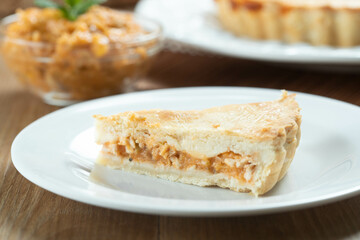 Close up piece of Chicken pie with cottage cheese, tomatoes, onion and olives on wooden table and white plate.