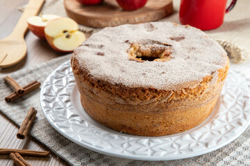 Sponge cake or chiffon cake with apples so soft and delicious sliced ​​with ingredients: cinnamon, eggs, flour, apples on wooden table. Home bakery concept for background and wallpaper