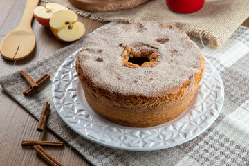 Sponge cake or chiffon cake with apples so soft and delicious sliced ​​with ingredients: cinnamon, eggs, flour, apples on wooden table. Home bakery concept for background and wallpaper