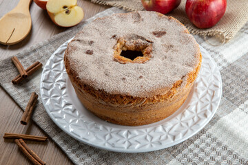 Sponge cake or chiffon cake with apples so soft and delicious sliced ​​with ingredients: cinnamon, eggs, flour, apples on wooden table. Home bakery concept for background and wallpaper