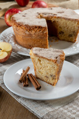 piece of sponge cake or chiffon cake with apples so soft and delicious sliced ​​with ingredients: cinnamon, eggs, flour, apples on wooden table. Home bakery concept for background and wallpaper