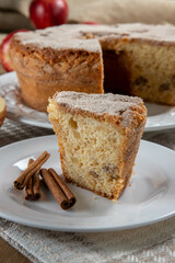 piece of sponge cake or chiffon cake with apples so soft and delicious sliced ​​with ingredients: cinnamon, eggs, flour, apples on wooden table. Home bakery concept for background and wallpaper
