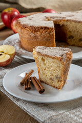 piece of sponge cake or chiffon cake with apples so soft and delicious sliced ​​with ingredients: cinnamon, eggs, flour, apples on wooden table. Home bakery concept for background and wallpaper