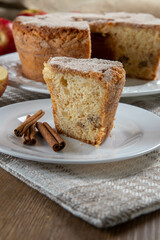 piece of sponge cake or chiffon cake with apples so soft and delicious sliced ​​with ingredients: cinnamon, eggs, flour, apples on wooden table. Home bakery concept for background and wallpaper