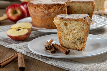 piece of sponge cake or chiffon cake with apples so soft and delicious sliced ​​with ingredients: cinnamon, eggs, flour, apples on wooden table. Home bakery concept for background and wallpaper
